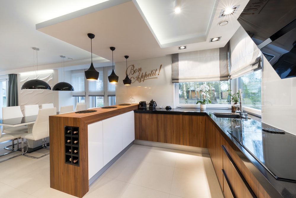 A bright, modern kitchen with wood-paneled cabinets and black countertops, like something you can find in the houses for rent with Columbia Property Management